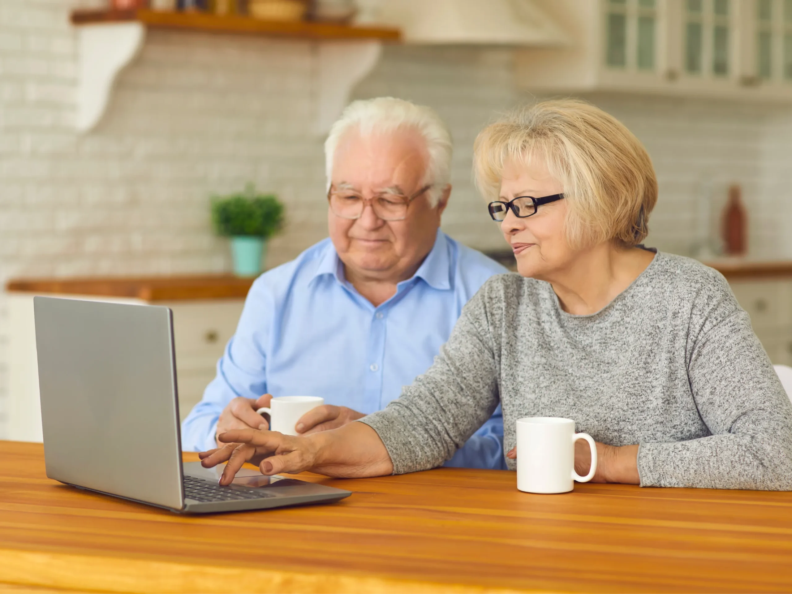 elderly couple face timing on laptop