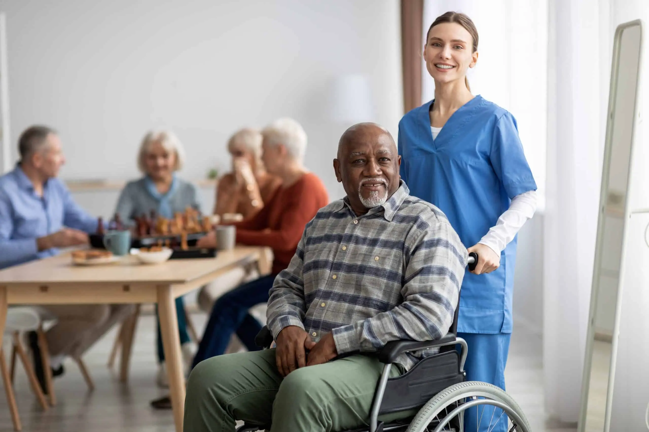 Man sitting in a wheel chair being pushed by a female nurse