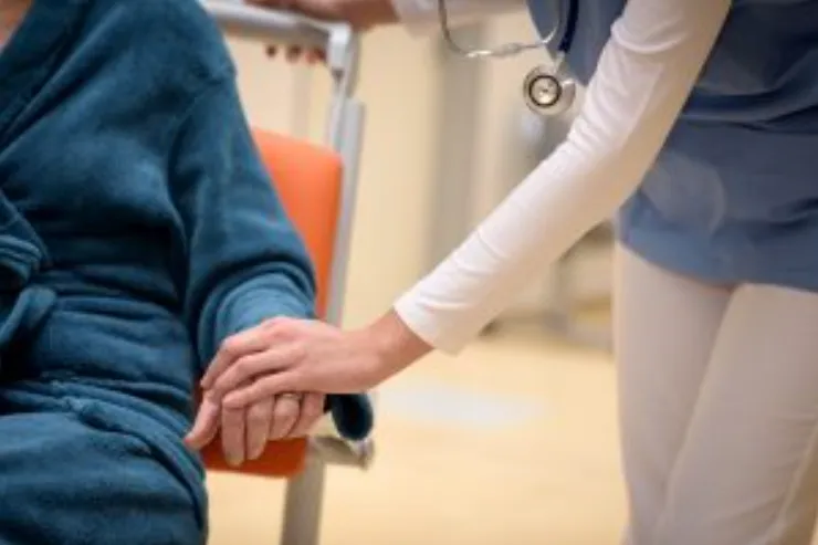 Caregiver with her hand on elderly persons hand 