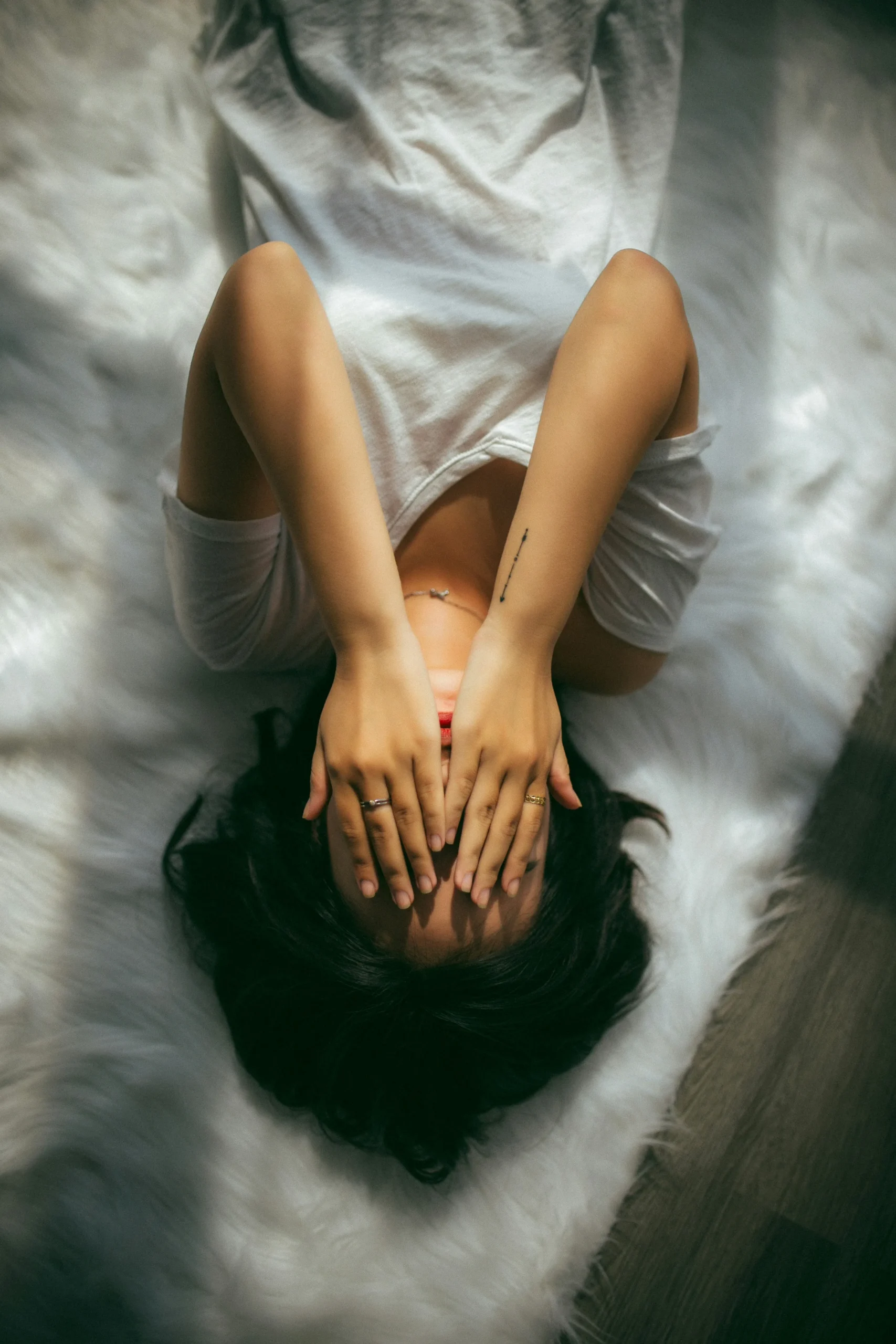 woman laying down with hands over eyes - indicating stress and burnout